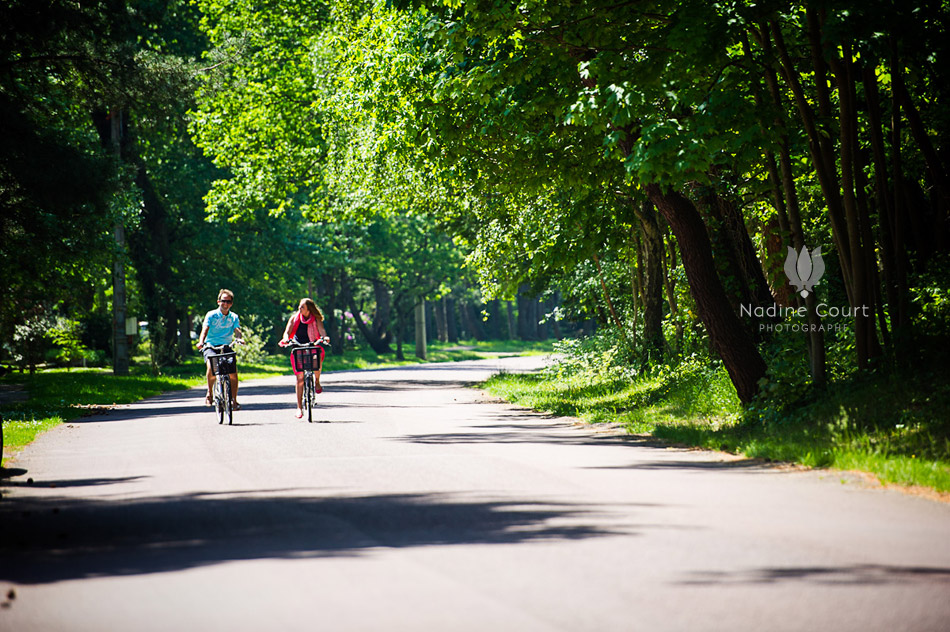 Couple à vélo arrivant sur une route avec des arbres
