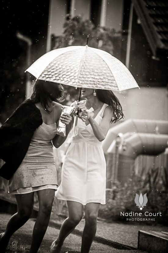 La mariée et un de ses témoins arrivant à la mairie sous la pluie