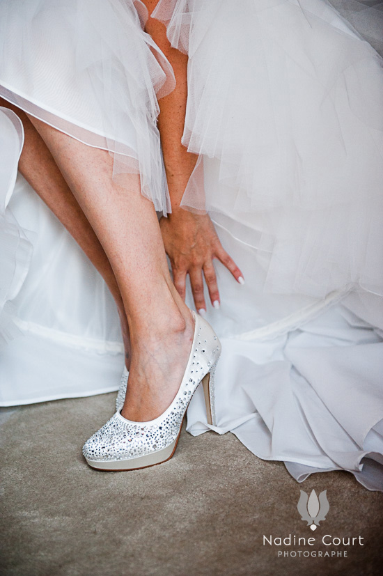 Mariée enfilant une chaussure blanche ornée de strass