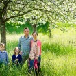 Portrait de famille dans un joli pré fleuri avec des arbres fruités en fleurs