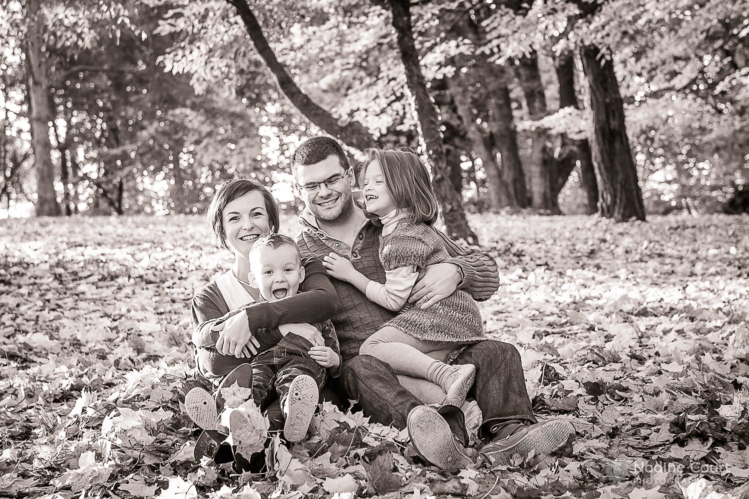 Photo de famille dans un tas de feuilles mortes en automne