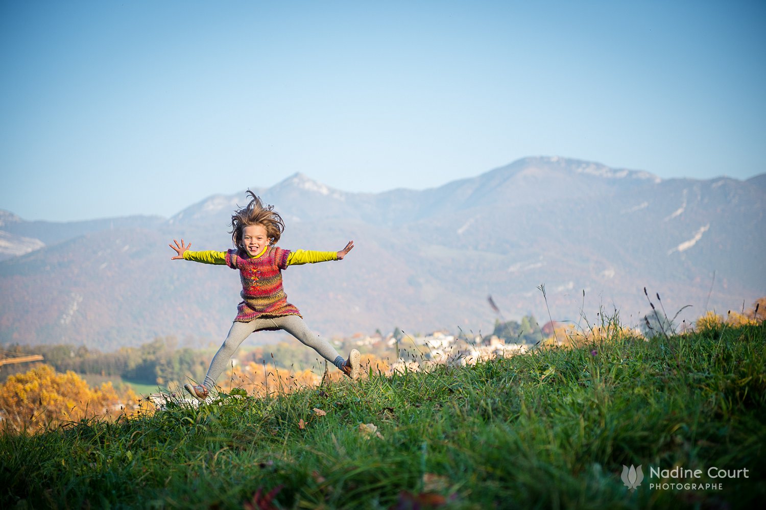 Photo d'une petite fille en train de sauter - pause dans les airs
